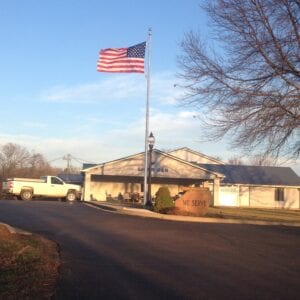 the American flag on a pole at a residential property